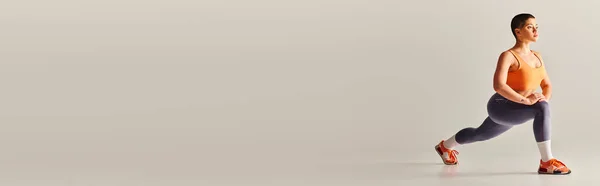 Movimento di positività del corpo, giovane donna dai capelli corti che fa affondi su sfondo grigio, modello di fitness curvy in abbigliamento sportivo, potenziamento, motivazione, allenamento, forza e salute, banner — Foto stock