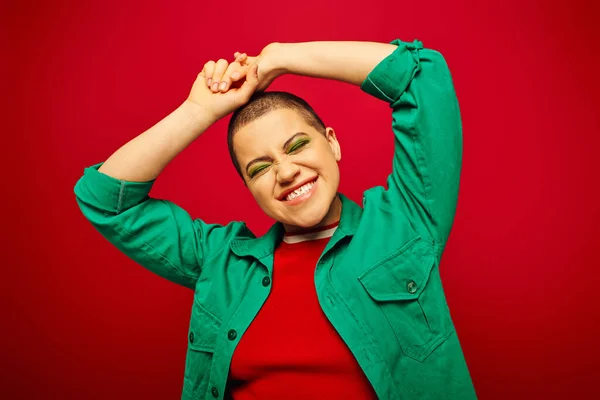 Positive vibe, generation z, youth culture, young woman with short hair smiling with closed eyes on red background, fashion statement, youth culture, casual wear, vibrant background — Stock Photo
