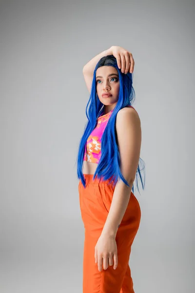 Mode-Statement, tätowierte junge Frau mit blauen Haaren posiert in bunten Kleidern auf grauem Hintergrund, Individualismus, moderner Stil, urbane Mode, lebendige Farbe, weibliches Modell, jugendliche Energie — Stockfoto