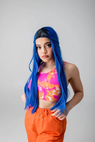 Modelo feminino, energia jovem, mulher jovem tatuada com cabelo azul posando em roupas coloridas em fundo cinza, individualismo, estilo moderno, moda urbana, cor vibrante, moda para a frente — Fotografia de Stock