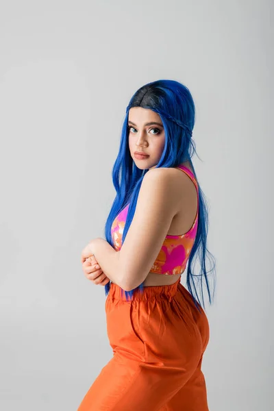 Moda para a frente, energia jovem, mulher jovem tatuada com cabelo azul olhando para a câmera em roupas coloridas em fundo cinza, individualismo, estilo moderno, moda urbana, cor vibrante, modelo feminino — Fotografia de Stock
