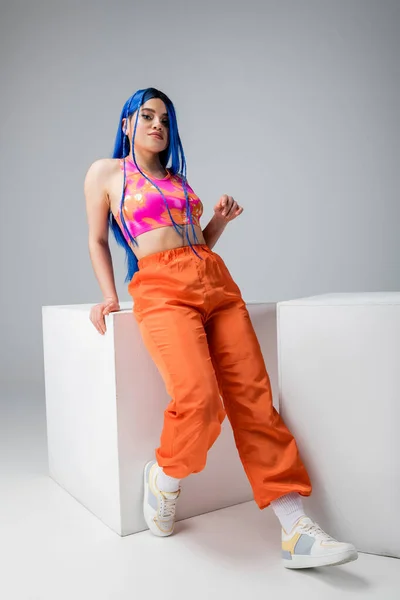 Fashion trends, tattooed young woman with blue hair posing in stylish look near white cubes on grey background, full length, individualism, modern style, urban fashion, vibrant color, model — Stock Photo