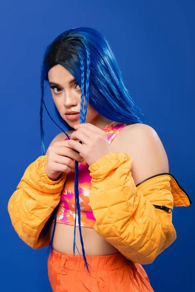 Colorful clothes, young woman with dyed hair posing in puffer jacket on blue background, vibrant color, urban fashion, individualism, young woman with rebel style,  female model with blue hair — Stock Photo