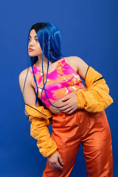 Mode-Statement, junge Frau mit gefärbten Haaren posiert in Pufferjacke auf blauem Hintergrund, lebendige Farbe, urbane Mode, Individualismus, junge Frau mit Rebellentyp, weibliches Model mit blauen Haaren — Stockfoto