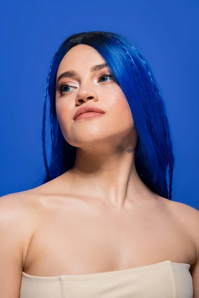 Schönheitstrends, junge Frau mit gefärbten Haaren posiert auf blauem Hintergrund, Haarfarbe, Individualismus, weibliches Model mit Make-up und trendiger Frisur, lebendige Jugend, Hautperfektion, Tätowierung — Stockfoto