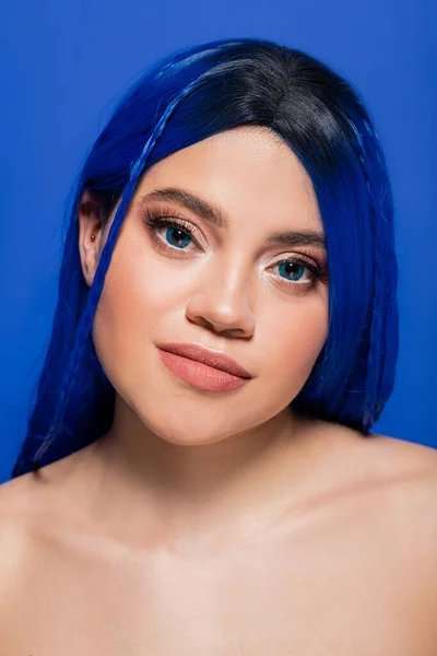 Gesichtspflege, hübsche junge Frau mit gefärbten Haaren posiert auf blauem Hintergrund, Haarfarbe, Individualismus, weibliches Model mit Make-up und trendiger Frisur, lebendige Jugend, Hautperfektion — Stockfoto