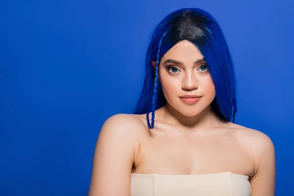 Modern beauty concept, young woman with dyed hair posing on blue background, hair color, individualism, female model with makeup and trendy hairstyle, vibrant youth, skin perfection — Stock Photo