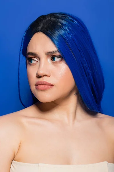 Conceito de tendências de beleza, retrato de mulher jovem descontente com cabelo tingido posando no fundo azul, cor do cabelo, individualismo, modelo feminino com maquiagem e penteado na moda, juventude vibrante, emocional — Fotografia de Stock