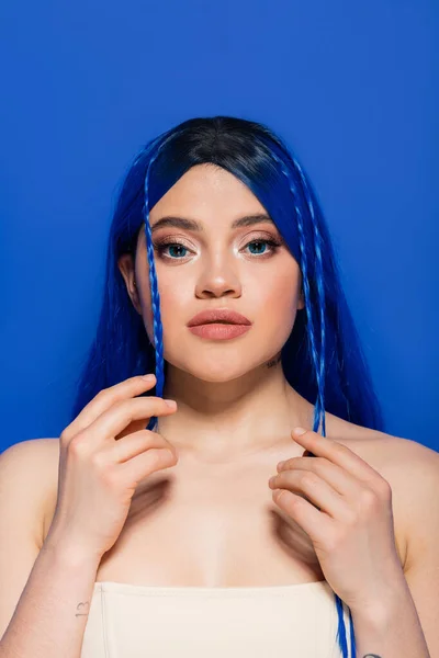 Lebendige Jugend, junge Frau mit gefärbten Haaren posiert auf blauem Hintergrund, Haarfarbe, Individualismus, weibliches Model mit Make-up und trendiger Frisur, Selbstausdruck — Stockfoto
