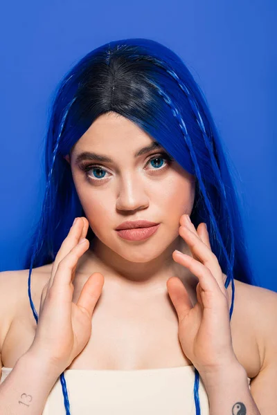 Modern subculture, self expression, portrait of young woman with dyed hair posing on blue background, hair color, individualism, female model with makeup and trendy hairstyle — Stock Photo