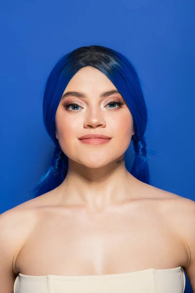 Glowing skin concept, portrait of confident young woman with vibrant hair posing with bare shoulders on bright blue background, youth, individualism, beauty trends, unique identity, looking at camera — Stock Photo