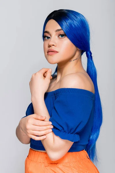 Schönheitstrends, gefärbte Haare, Sommermode, tätowierte junge Frau mit nackten Schultern posiert in heller Bluse auf grauem Hintergrund, blaue Haarfarbe, Frisur, weibliches Modell, Make-up und Schönheit — Stockfoto