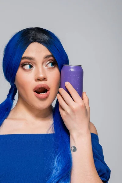 Summer concept, amazed young woman with blue hair holding soda can on grey background, modern subculture, individualism, youth and lifestyle, vibrant color, self expression, unique identity — Stock Photo