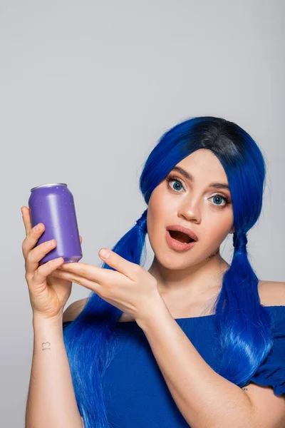 Sommerkonzept, staunende junge Frau mit blauen Haaren, die eine Getränkedose auf grauem Hintergrund hält, Individualismus, Jugend und Lifestyle, lebendige Farbe, Selbstausdruck, einzigartige Identität, moderne Subkultur — Stockfoto