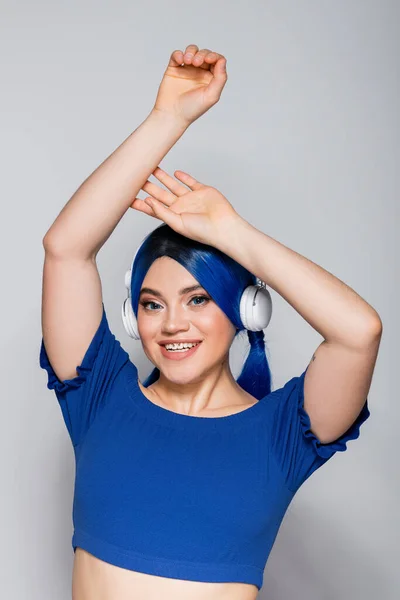 Selbstausdruck, glückliche junge Frau mit gefärbten Haaren, die Musik in drahtlosen Kopfhörern auf grauem Hintergrund hört, lebendige Jugend, Individualismus, moderne Subkultur, Tätowierung, Sound — Stockfoto