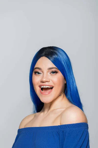 Excitação e juventude, mulher tatuada com olhos azuis e cabelos tingidos sorrindo em fundo cinza, penteado, cabelo azul, beleza moderna, auto-expressão, individualismo — Fotografia de Stock