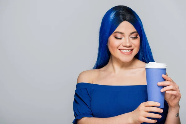 Taza de papel, mujer joven feliz con el pelo azul y los ojos sosteniendo café para ir sobre fondo gris, comida para llevar, cafeína, energía, tatuaje, color vibrante, auto expresión, individualismo - foto de stock