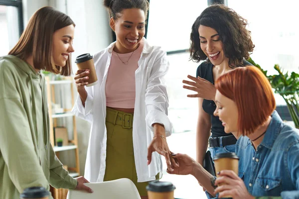 Young and pleased african american woman showing new ring to amazed multiethnic girlfriends in women interest club, happy gathering and leisure of diverse female team — Stock Photo