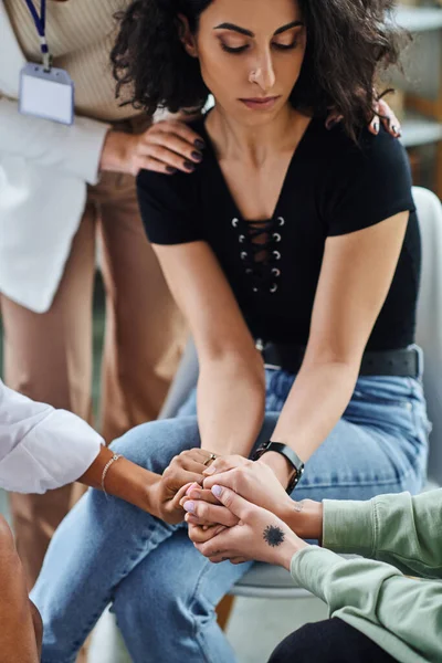 Professional psychologist and multicultural female friends calming upset and depressed multiracial woman during supportive therapy, problem-solving and mental wellness concept — Stock Photo