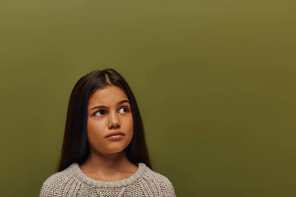 Портрет вдумливої дівчини-підлітка брюнетки в стильному в'язаному светрі, яка дивиться в очі, стоячи і позуючи ізольовано на зеленій, стильній дівчині в затишній концепції одягу осені — стокове фото