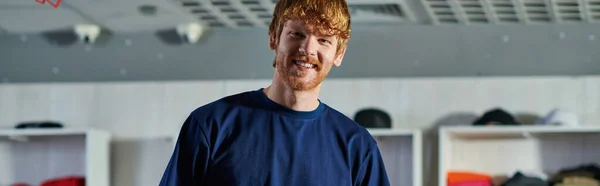Portrait of young redhead craftsman in casual clothes looking at camera while standing in blurred print studio at background, self-made success concept, banner — Stock Photo