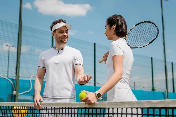 Happy man and woman talking on tennis court, summer sport, couple leisure, outdoor fitness — Stock Photo