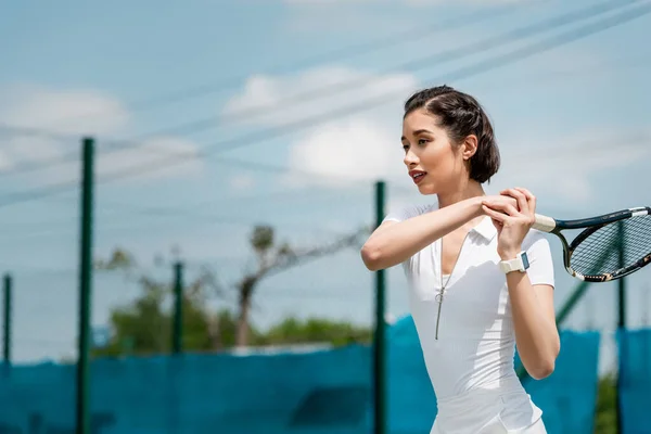 Bela mulher em desgaste ativo segurando raquete e jogando tênis na quadra, esporte e verão — Fotografia de Stock