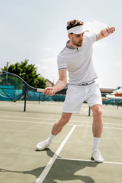 Deportista en visera deportiva sosteniendo raqueta y jugando al tenis en pista, entrenamiento y motivación - foto de stock