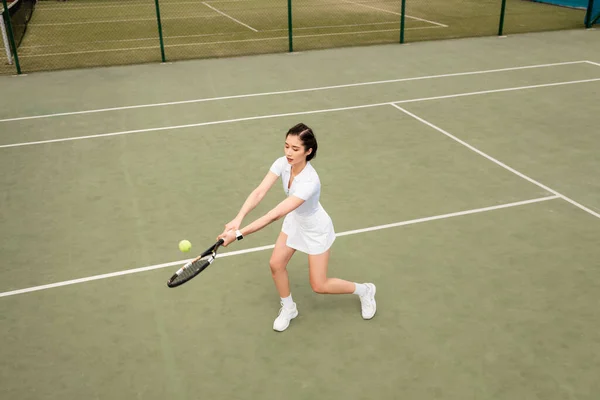 Заздалегідь, вид зверху на жіночого гравця в активний одяг, граючи в теніс, ракетку і м'яч, спорт — стокове фото