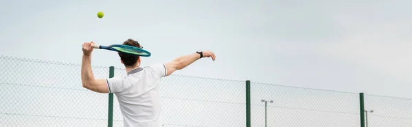 Банер, задня рука, чоловік грає в теніс на корті, тримає ракетку, вдарив м'яч, задня рука, вид ззаду — стокове фото
