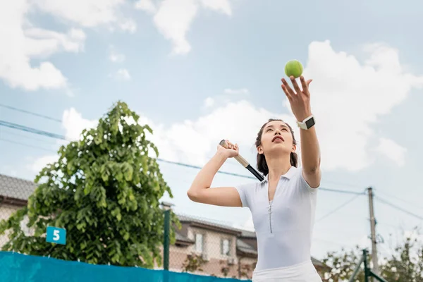 Низький кут зору спортсменка б'є по м'ячу під час гри в теніс, тримає ракетку, мотивація — стокове фото