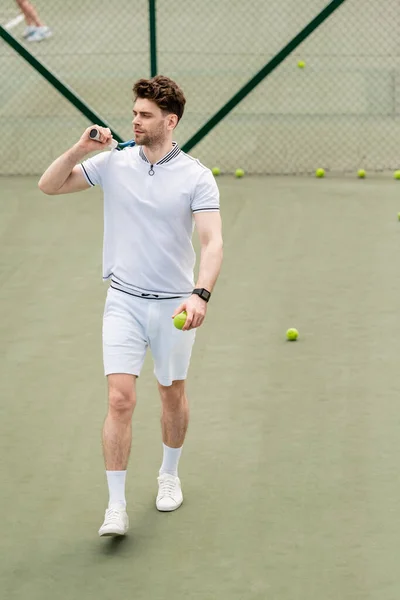 Bela esportista segurando raquete de tênis e andando na quadra, treinamento e motivação — Fotografia de Stock