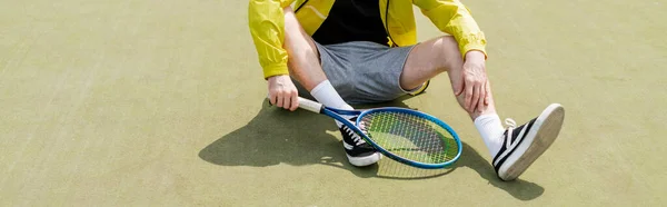 Banner, vista cortada do jogador de tênis masculino sentado na quadra e segurando raquete, homem em desgaste ativo — Fotografia de Stock