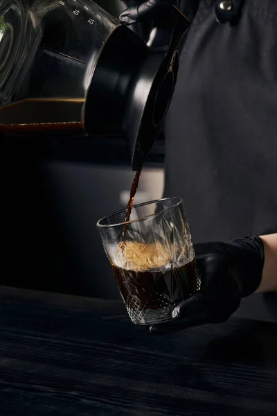 Alternative brewing way, barista pouring fresh and delicious espresso from coffee pot into glass — Stock Photo