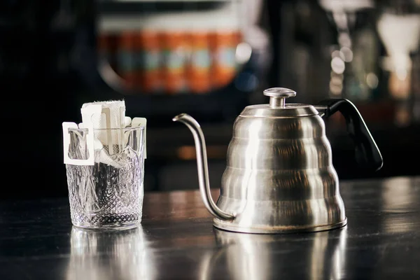 Металлический капельный чайник и бумажный фильтр с натуральным кофе на черном деревянном счетчике, метод переливания — стоковое фото