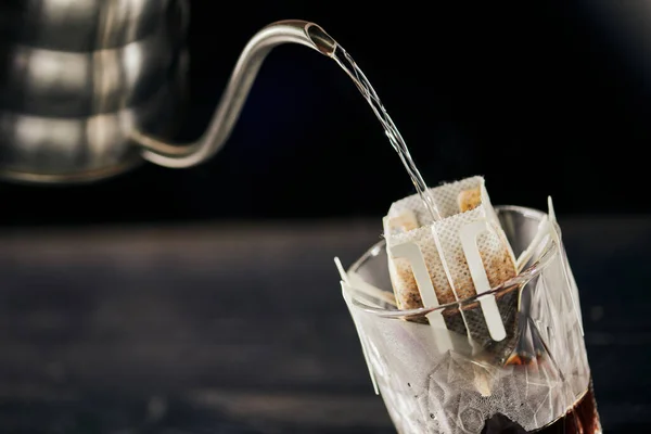 Pour-over café expresso, água fervente derramando de chaleira gotejamento em vidro com café no filtro de papel — Fotografia de Stock