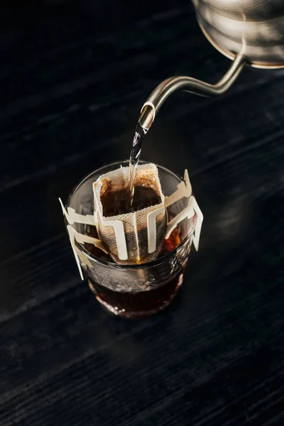 Альтернативное пиво, ароматный эспрессо, кипящая вода, наливаемая в стекло с кофе в бумажном фильтре — стоковое фото