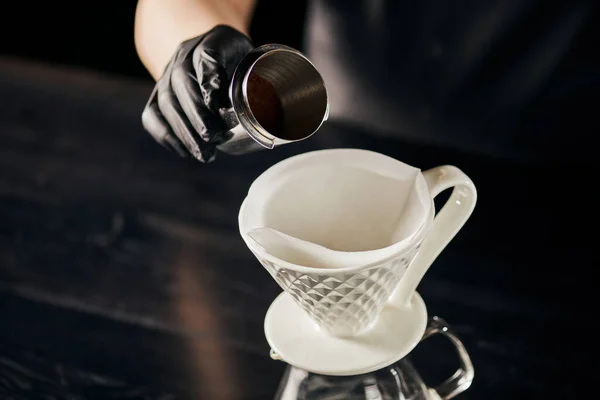 V-60 estilo espresso método, barista segurando jigger com café moído fino perto de gotejador de cerâmica — Fotografia de Stock