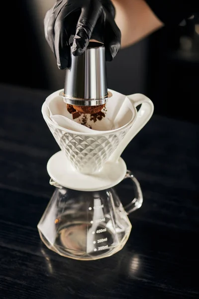 Barista derramando café moagem fina de jigger em gotejador de cerâmica em panela de vidro, V-60 espresso estilo — Fotografia de Stock