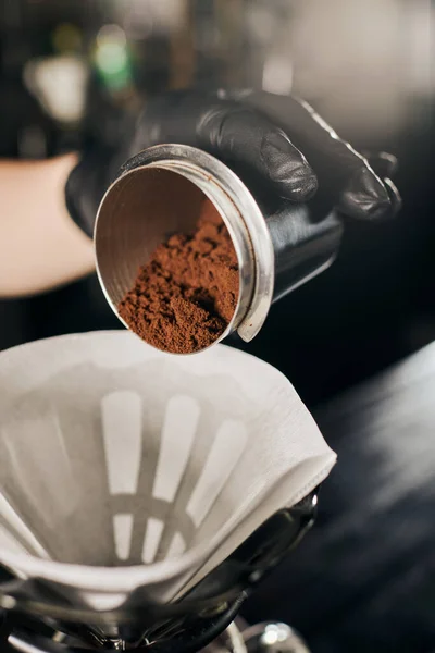 Espresso in stile V-60, barista che versa caffè macinato dal jigger al filtro di carta sul gocciolatore — Foto stock