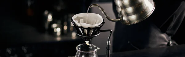 Barista pouring boiling water into coffee filter on dripper stand above glass pot, V-60 style, banner — Stock Photo