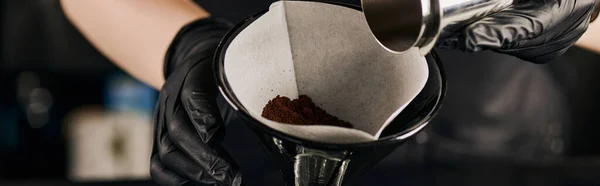 Vista cortada de barista segurando filtro de papel com café moído perto de sifão cafeteira, banner — Fotografia de Stock