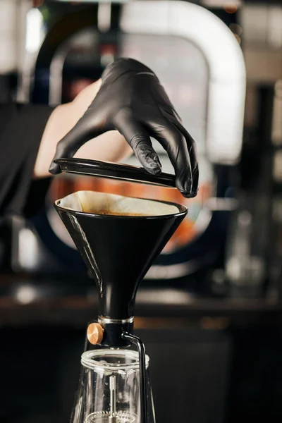 Vista recortada de barista en guante negro preparando pour-over espresso y apertura sifón cafetera - foto de stock