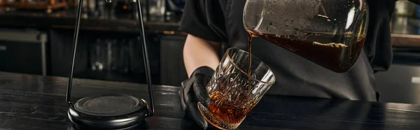 Vista parcial do barista derramando café expresso acabado de fazer da panela de café em vidro de cristal, banner — Fotografia de Stock