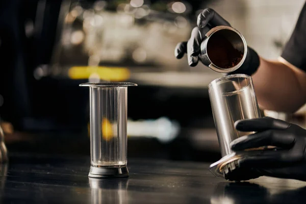 Partial view of barista preparing pour-over espresso and pouring ground coffee in aero press — Stock Photo