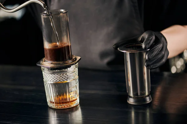 Partial view of barista pouring boiling water in aero press coffee maker, alternative espresso method — Stock Photo