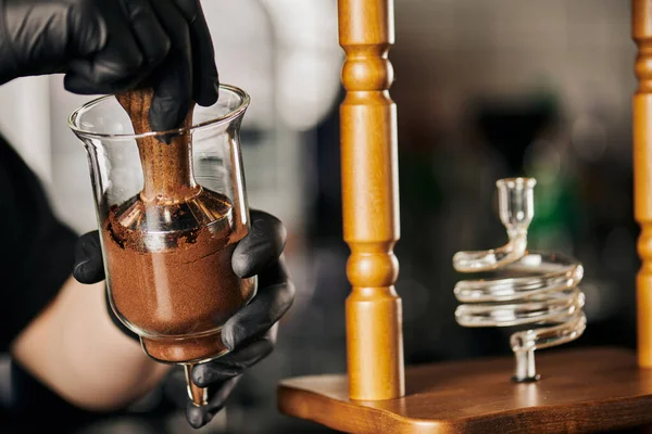 Teilansicht des Barista Pressens von gemahlenem Kaffee mit Stampfer in Kaltbrühkaffeemaschine, alternative Methode — Stockfoto