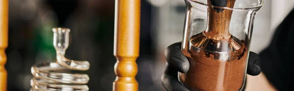 Partial view of barista pressing coffee in cold brew coffee maker with tamper while preparing espresso — Stock Photo