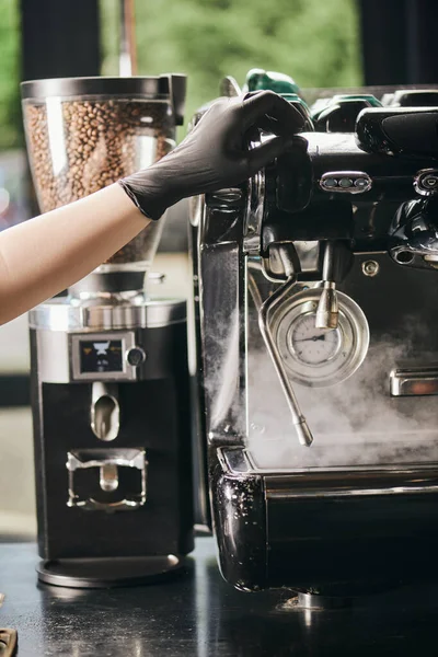 Máquina de café profissional, vista cortada de barista em luva de látex perto de vapor e moedor de café — Fotografia de Stock