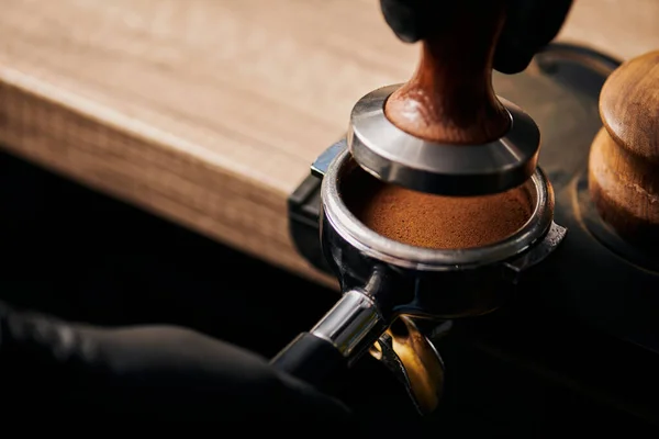 Barista hält Stampfer in der Nähe von Portafilter mit gemahlenem Kaffee, Espresso, Handpresse — Stockfoto